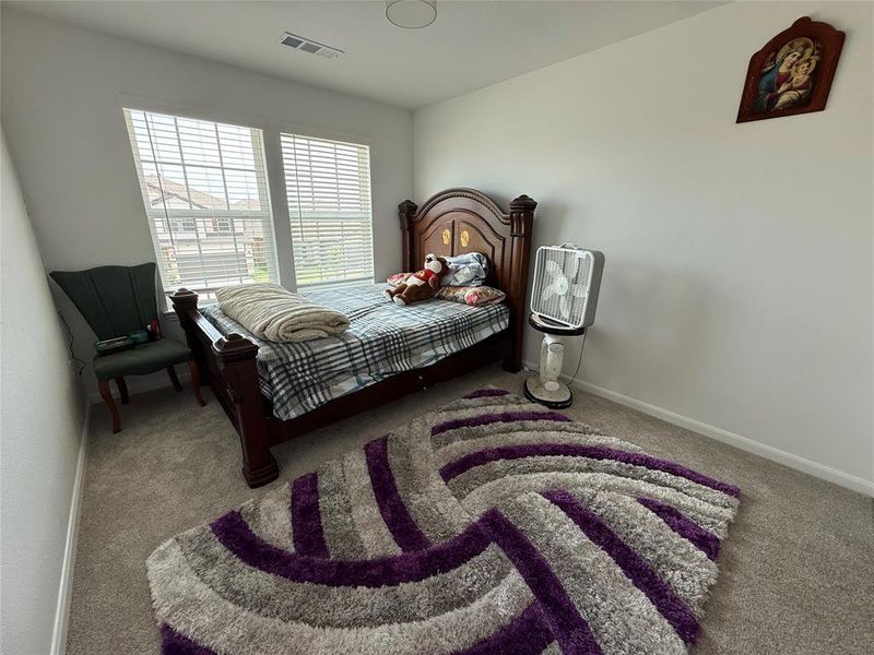 Carpeted room featuring multiple windows with blinds, white walls, and an overhead light fixture