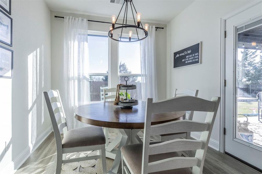 Dining space with wood-type flooring and a chandelier