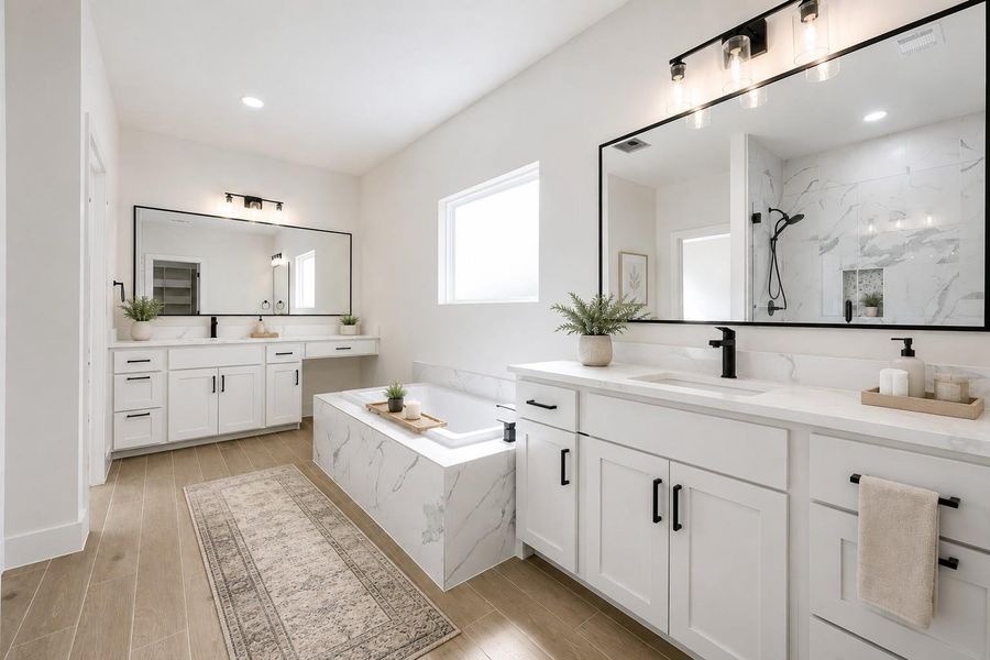 Luxurious primary bathroom featuring dual vanities with expansive mirrors and a sleek, built-in soaking tub.