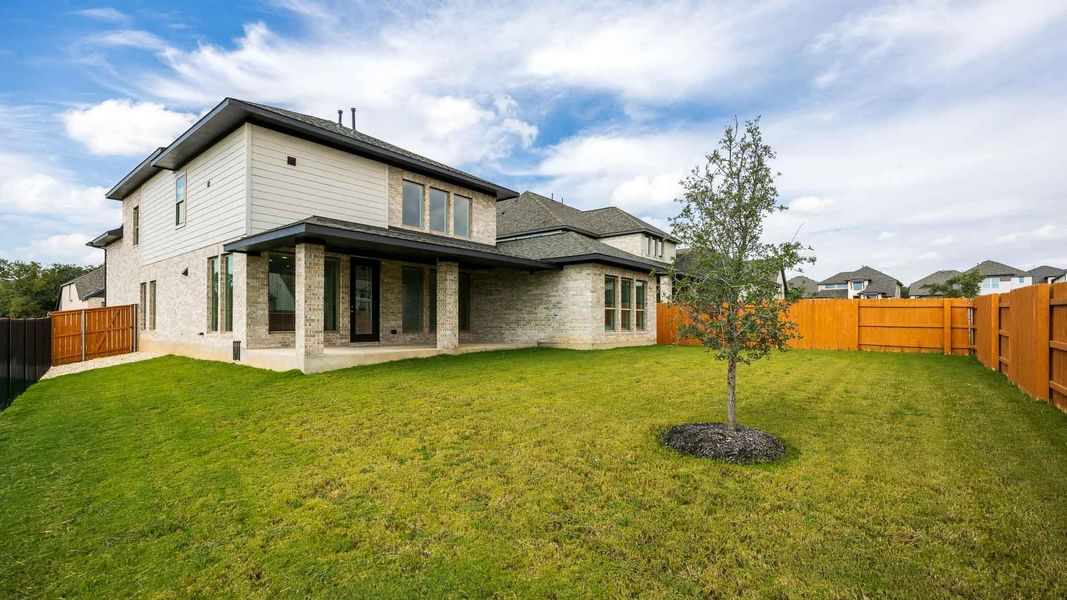 Rear view of property featuring a fenced backyard and a patio