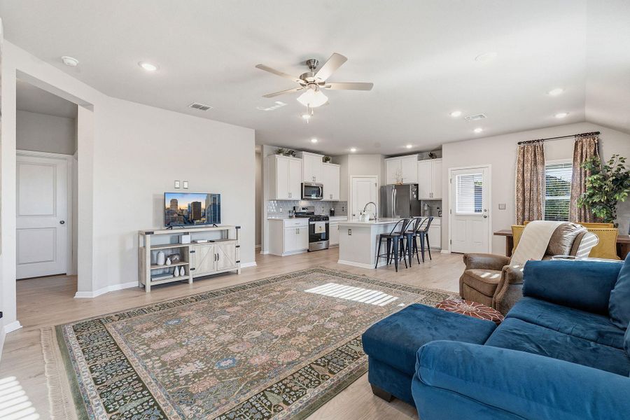 Living area with a ceiling fan, light wood-style flooring, and recessed lighting Living area with a ceiling fan, light wood-style flooring, and recessed lighting