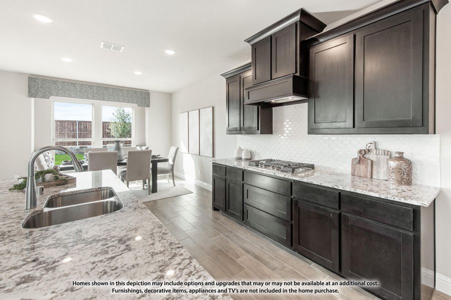 Kitchen with dark cabinets, granite countertops, stainless sink, and gas cooktop open to dining area with large windows Kitchen with dark cabinets, granite countertops, stainless sink, and gas cooktop open to dining area with large windows