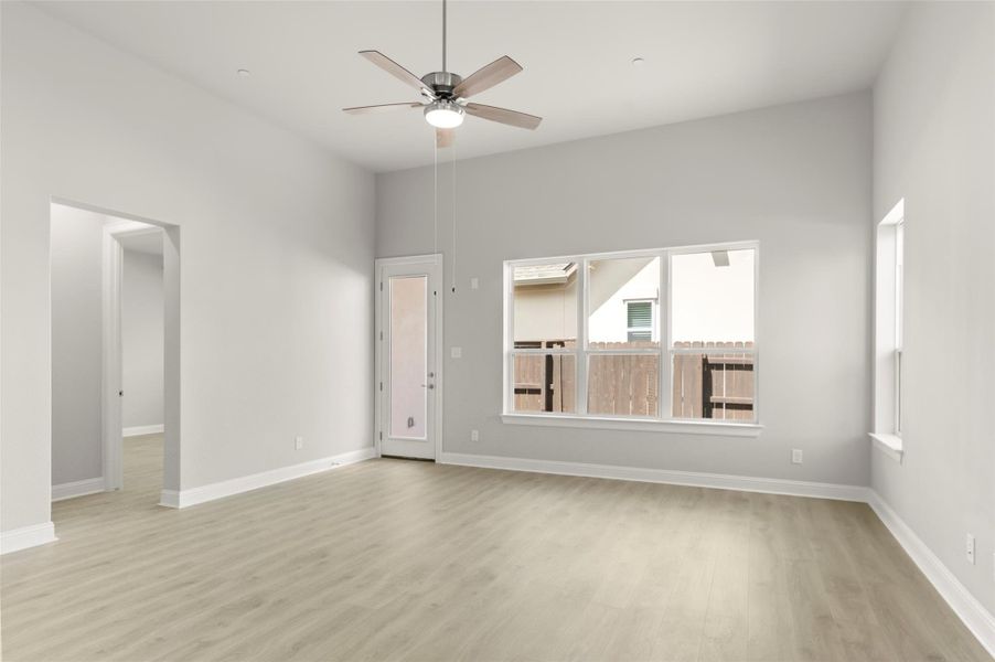 Spare room with light wood-style floors, ceiling fan, and plenty of natural light Spare room with light wood-style floors, ceiling fan, and plenty of natural light
