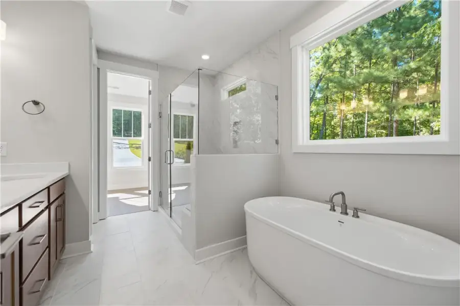 Sleek tile floors, a glass-enclosed shower, and a