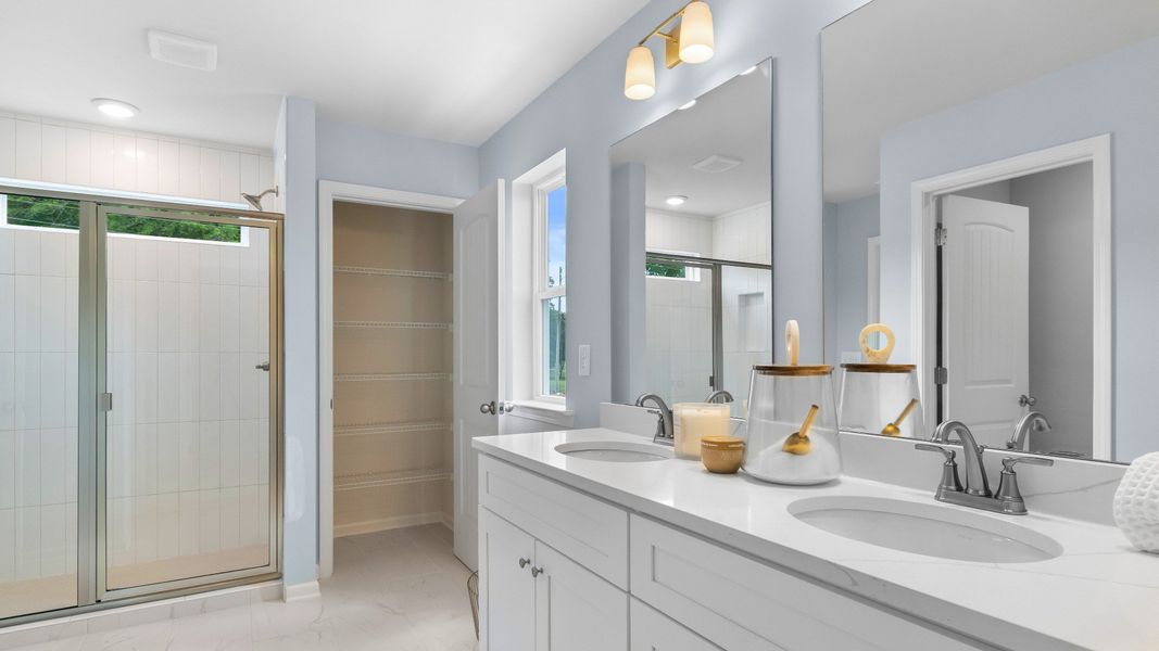 Relax and refresh in the primary suite tiled shower and dual-sink vanity Relax and refresh in the primary suite tiled shower and dual-sink vanity