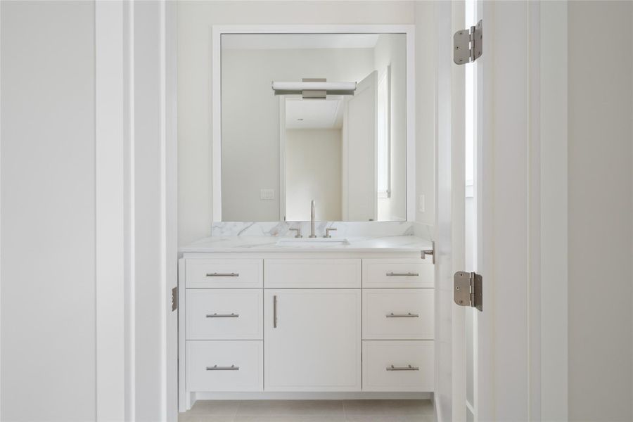 Bright secondary bath with clean-lined vanity and crisp, timeless finishes.