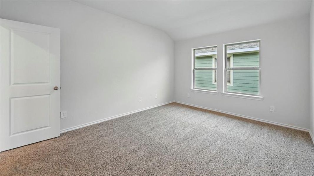 Unfurnished room featuring vaulted ceiling and carpet flooring