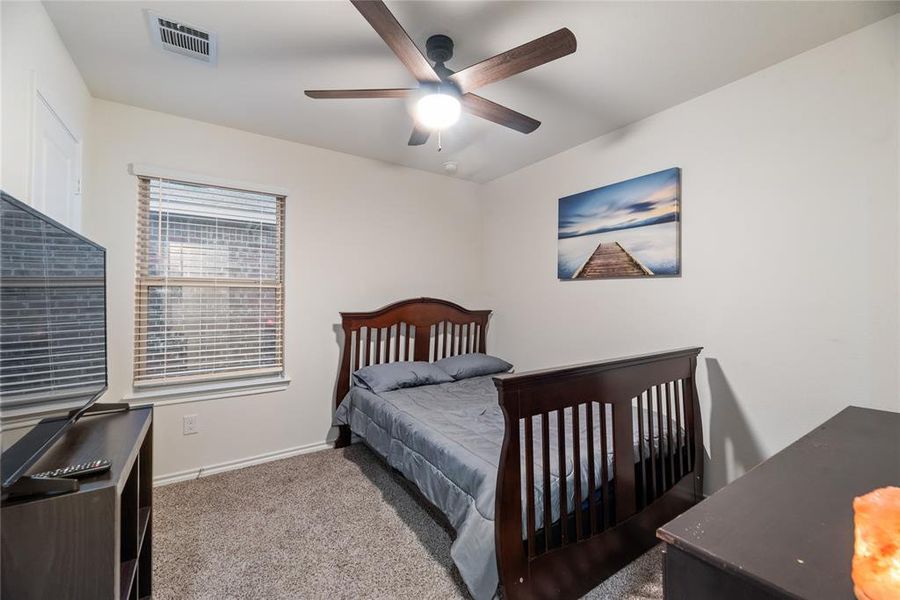 Bedroom with light carpet and a ceiling fan