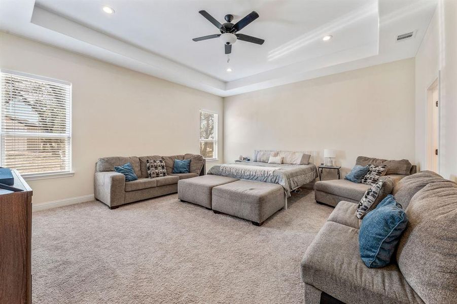 Living area featuring a raised ceiling, carpet floors, recessed lighting, and a ceiling fan Living area featuring a raised ceiling, carpet floors, recessed lighting, and a ceiling fan