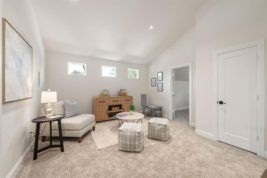 Living area featuring carpet and high vaulted ceiling Living area featuring carpet and high vaulted ceiling
