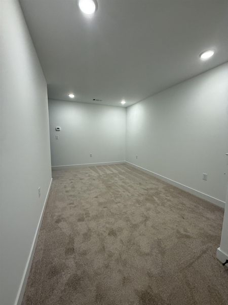 Empty room with recessed lighting and light carpet