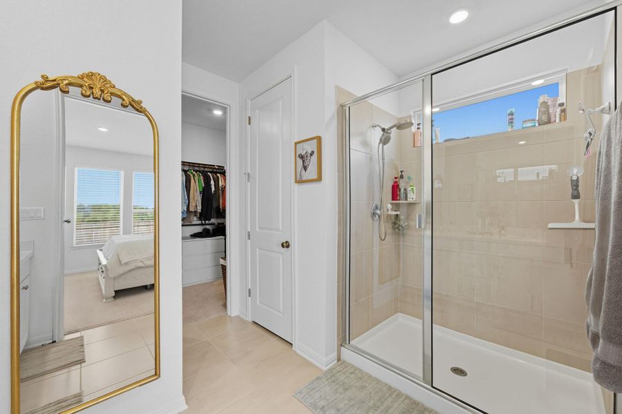 Full bathroom with a shower stall, light tile patterned flooring, recessed lighting, ensuite bath, and a spacious closet Full bathroom with a shower stall, light tile patterned flooring, recessed lighting, ensuite bath, and a spacious closet
