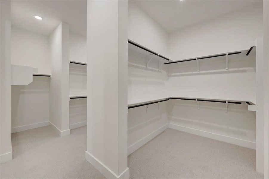Owners Walk in closet featuring light colored carpet