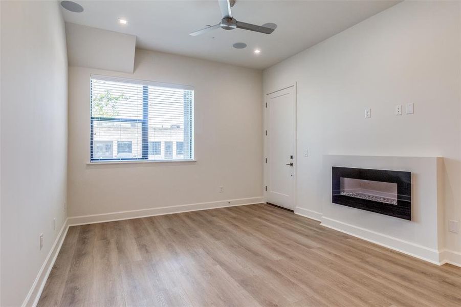 Unfurnished living room with light hardwood / wood-style floors and ceiling fan