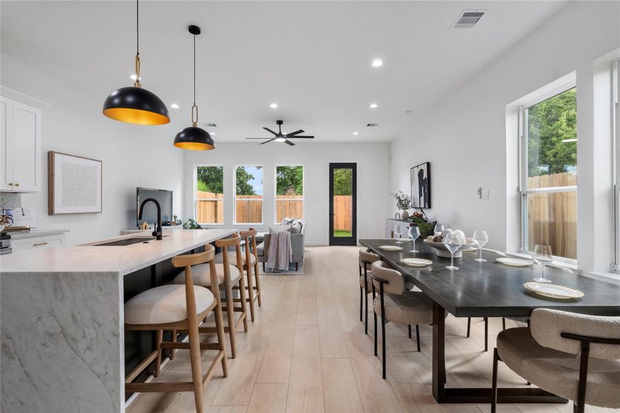 Open-concept living anchored by a quartz waterfall island and expansive windows. Open-concept living anchored by a quartz waterfall island and expansive windows.