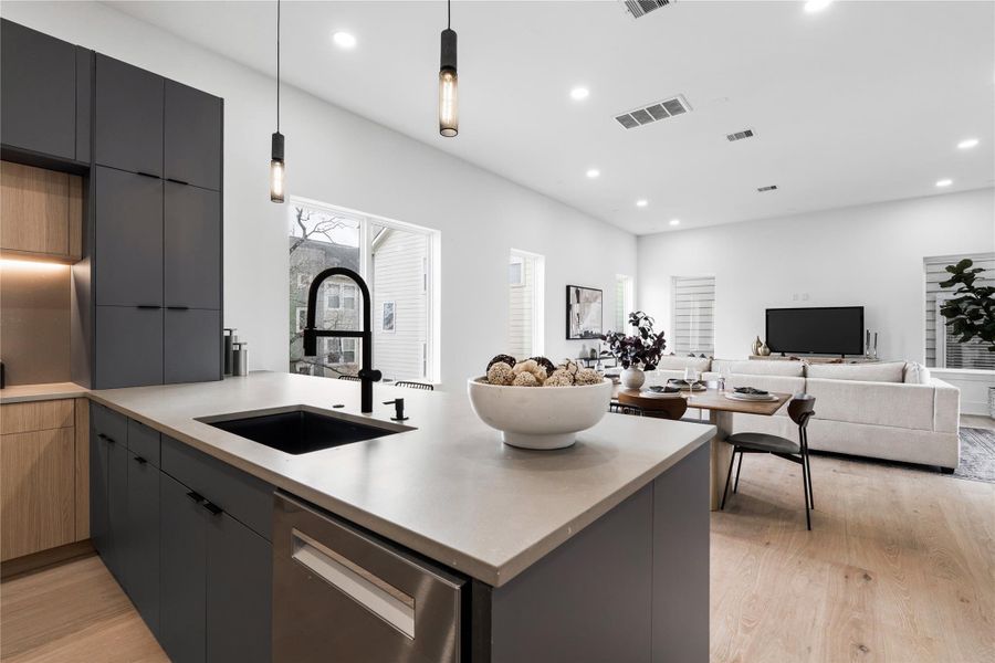 Rooted in Scandinavian minimalism and elevated by tailored execution, the kitchen at 1030 W 24th is both striking and deeply functional. Two-toneEuropean flat-front cabinetry in matte black and warm wood offers sculptural contrast, while a waterfall island anchors the space in quiet luxury. Outfitted with Bosch appliances and a matte black faucet, this culinary core is as much about performance as it is about presence—inviting everything from casual breakfasts to curated dinner parties