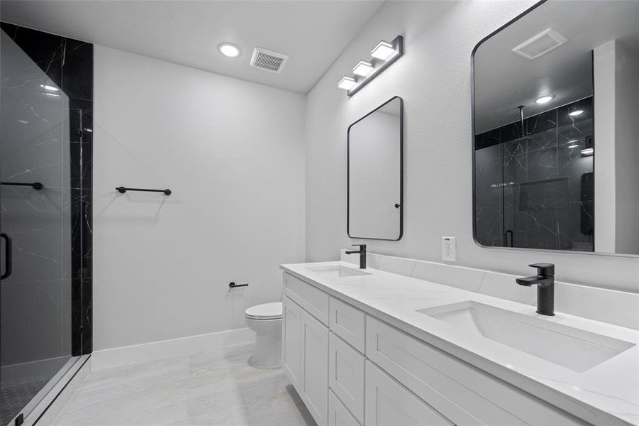 Bathroom featuring a sink, visible vents, and a marble finish shower