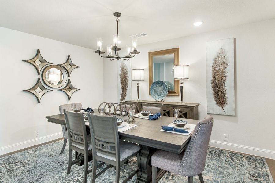Formal dining room with dark wood table, six chairs, chandelier, and buffet sideboard against white walls