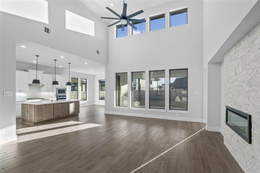 Upon entering this area, one immediately feels a sense of profound awe and airy freedom as the soaring ceilings and multiple tiers of oversized windows create an expansive, light-filled sanctuary. This grand Great Room seamlessly flows into a gourmet kitchen and breakfast room!