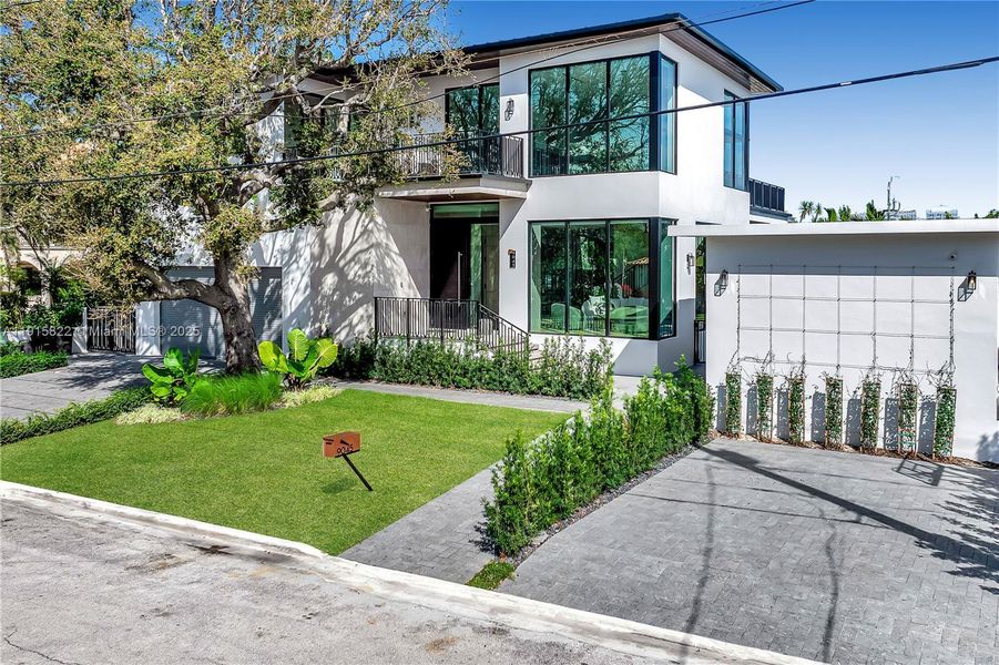 Front exterior of a new home in , Surfside, FL, highlighting curb appeal (Image 1). Front exterior of a new home in , Surfside, FL, highlighting curb appeal (Image 1).