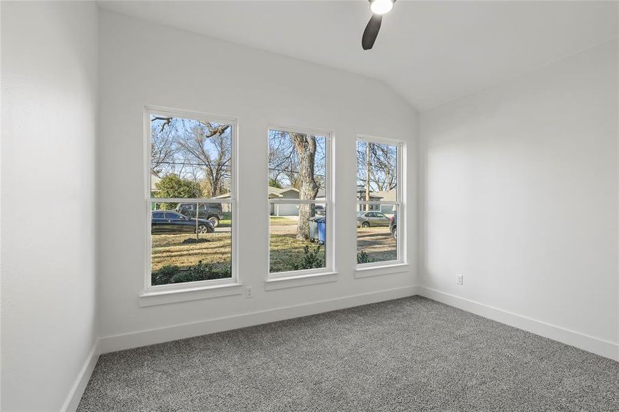 Empty room featuring carpet floors, ceiling fan, and lofted ceiling