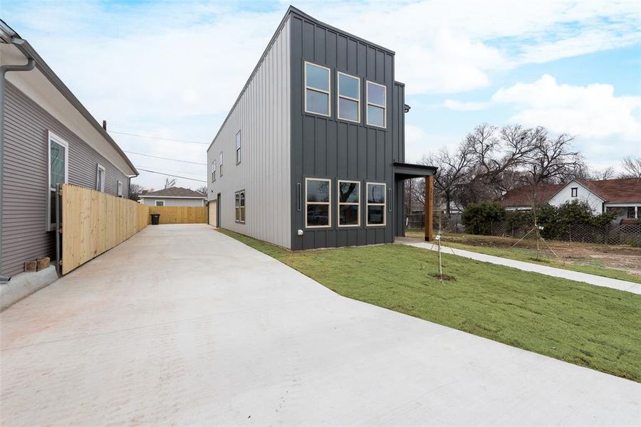 View of front of home with fence, a front lawn, and board and batten siding