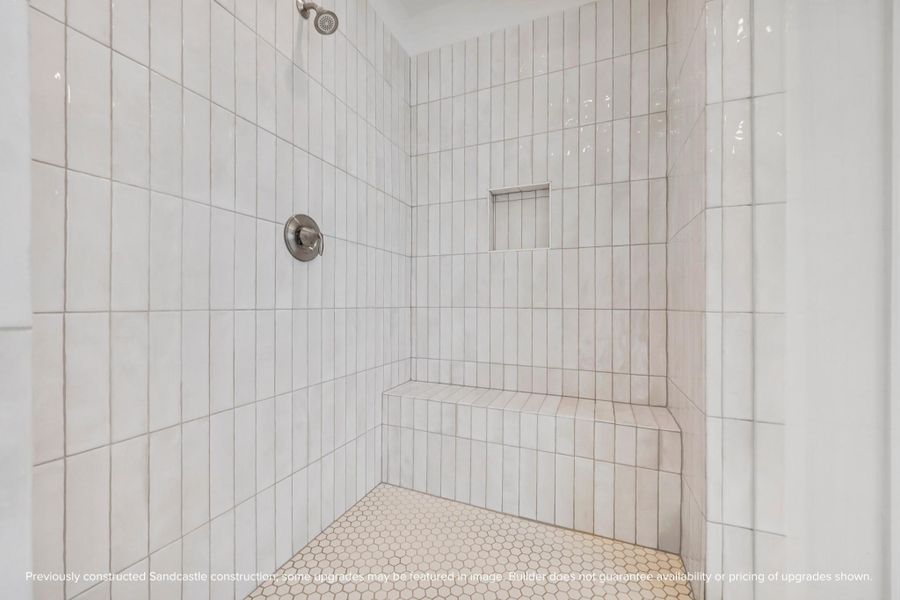 Built for both comfort and longevity, the tiled shower includes bench seating and clean, vertical lines that feel fresh and modern.