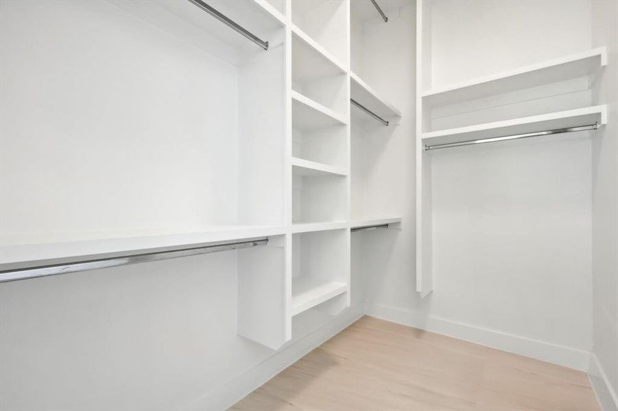 Walk in closet with light wood-type flooring