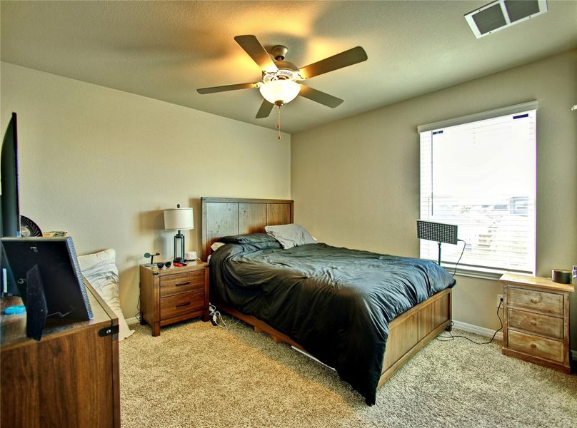 Bedroom featuring light colored carpet and a ceiling fan Bedroom featuring light colored carpet and a ceiling fan