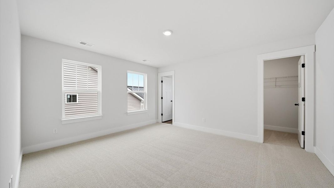 Vibrant and restful bedroom with oversized windows, refined detail, and a warm, welcoming atmosphere