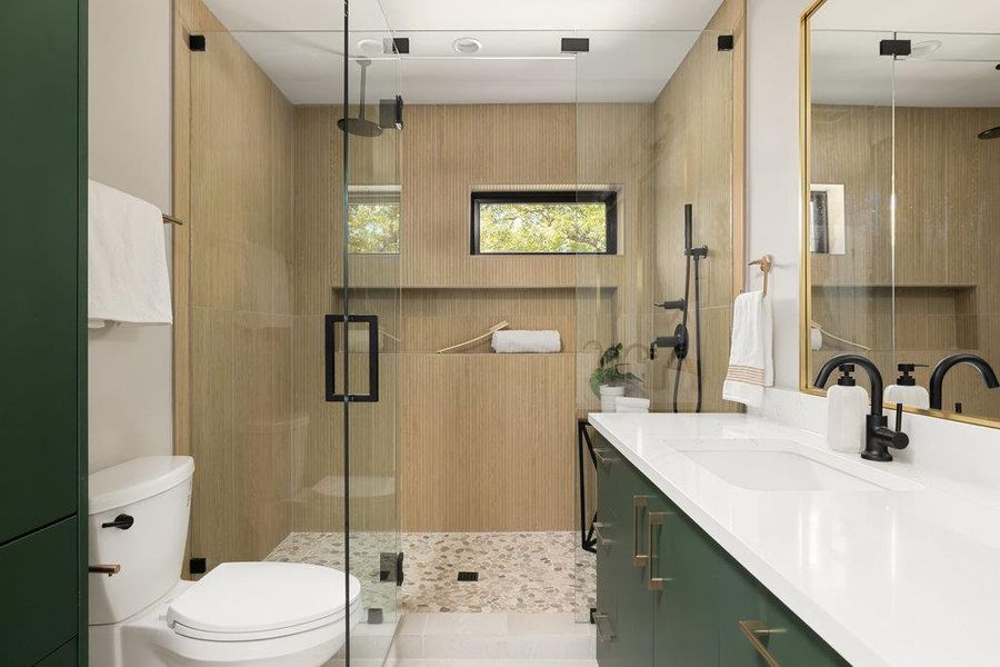 Full bath featuring vanity, a stall shower, and light tile patterned floors Full bath featuring vanity, a stall shower, and light tile patterned floors