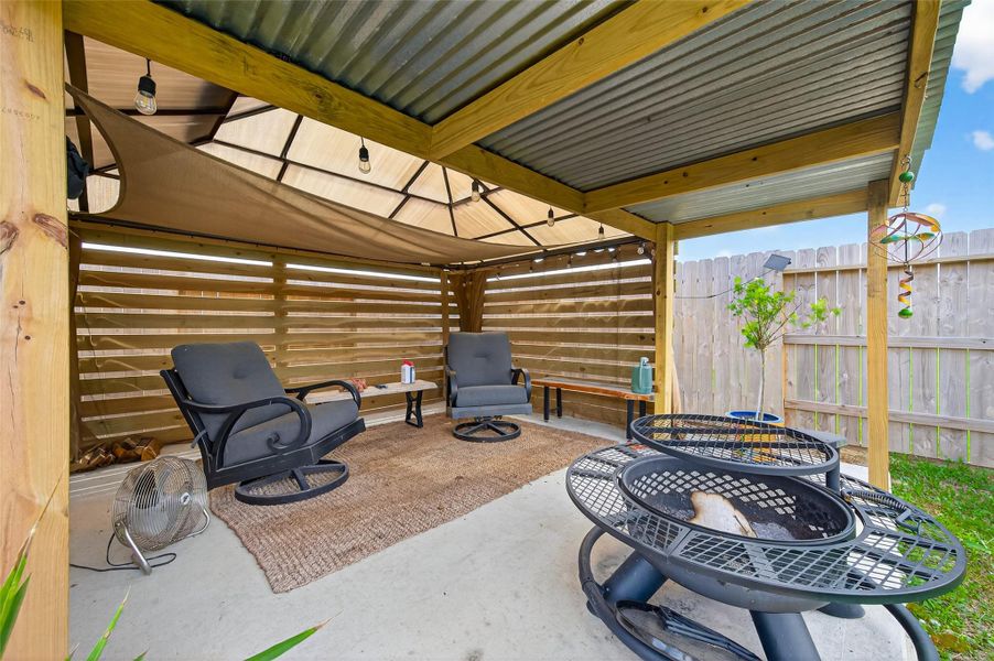 Backyard covered structure providing an additional seating area for a comfortable outdoor retreat