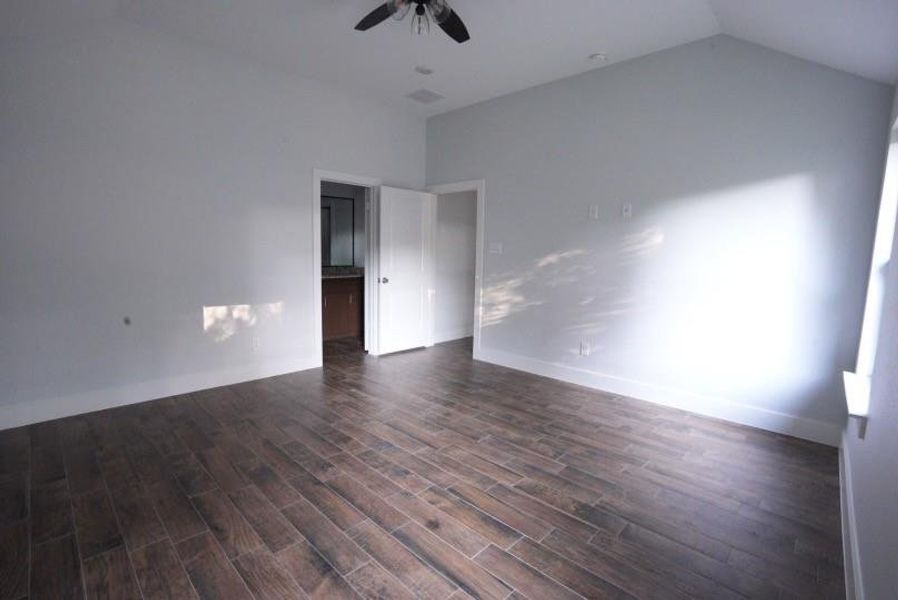 Empty room featuring dark wood-style flooring and a ceiling fan Empty room featuring dark wood-style flooring and a ceiling fan