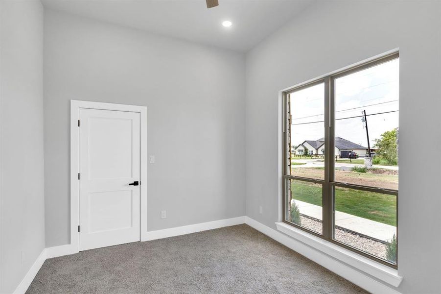 Empty room featuring light colored carpet, a residential view, and recessed lighting