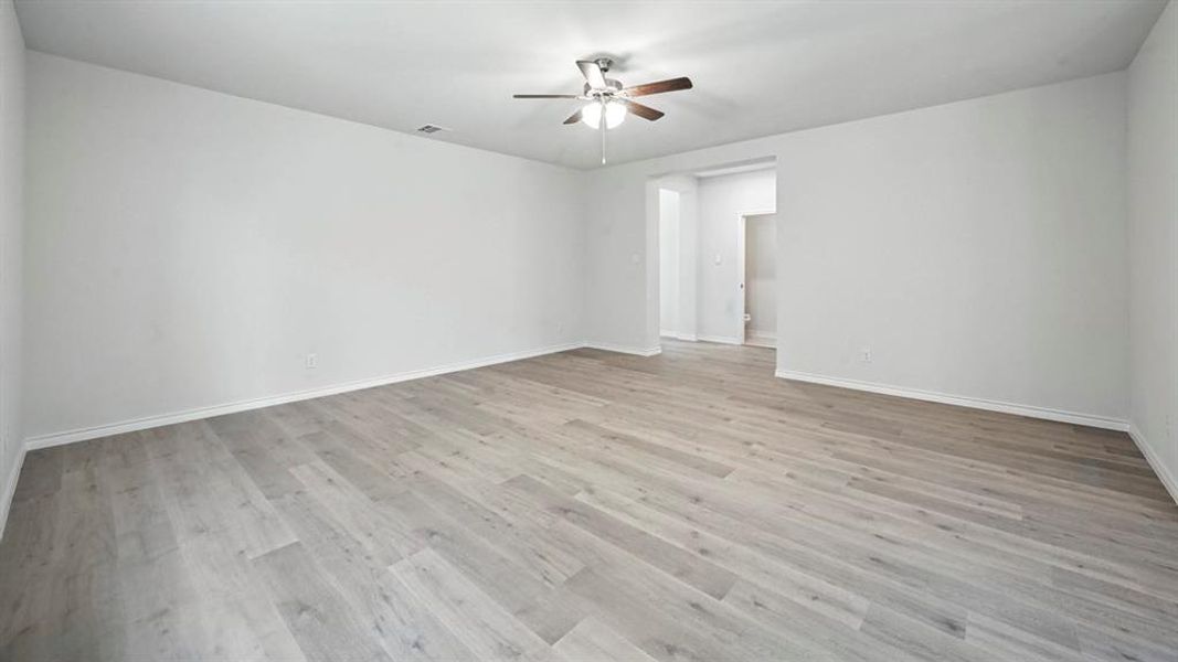 Empty room with light wood-style floors and a ceiling fan Empty room with light wood-style floors and a ceiling fan