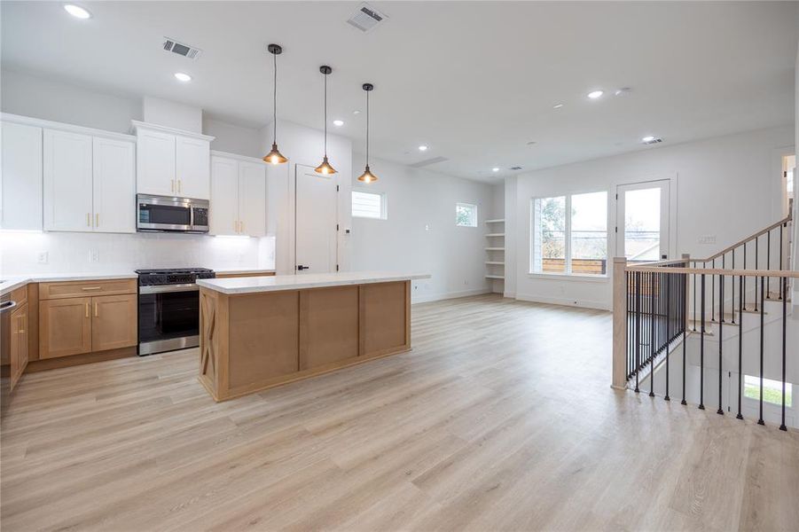 The spacious second floor boasts an open-concept layout, with the kitchen serving as the heart of the home, seamlessly connecting the living and dining areas.