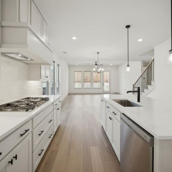 Modern kitchen featuring white cabinetry, light-toned wood-finish flooring, and recessed lighting