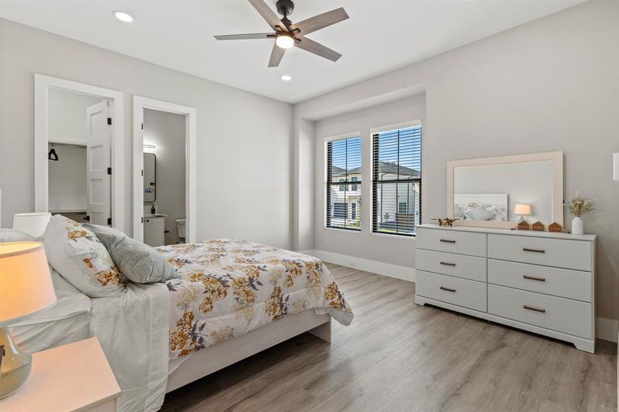 Bedroom featuring light wood-style floors, ceiling fan, connected bathroom, and recessed lighting