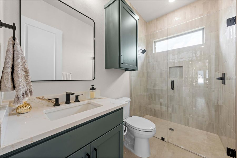 Modern bathroom featuring a vanity with elegant counters, a sleek mirror, and a spacious glass-enclosed shower. Modern bathroom featuring a vanity with elegant counters, a sleek mirror, and a spacious glass-enclosed shower.