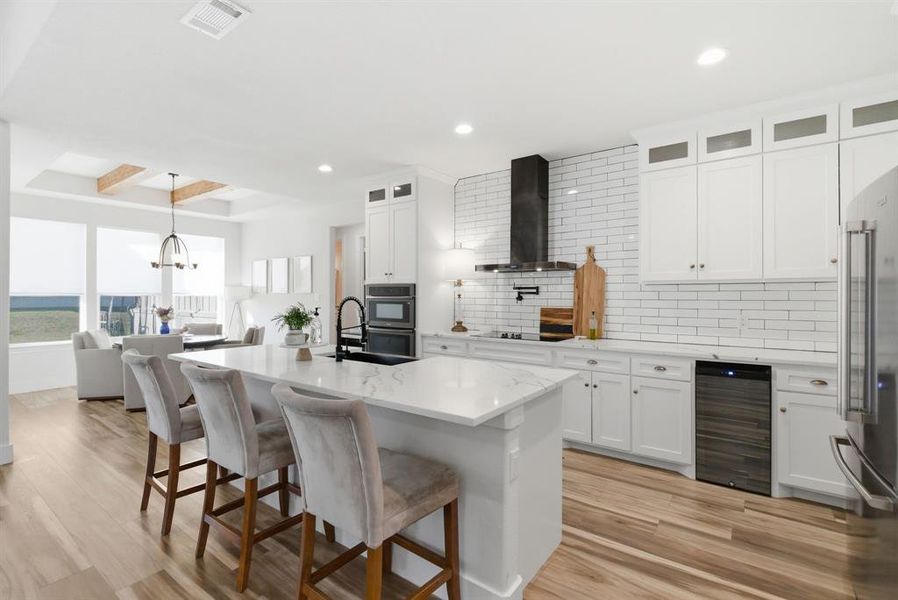 Kitchen featuring backsplash, a breakfast bar, glass insert cabinets, beamed ceiling, and hanging light fixtures