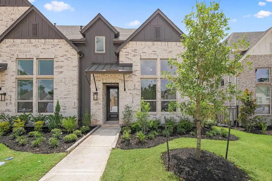 Front exterior of a new home in Woodforest Townhomes: Townhomes: The Villas, Montgomery, TX, highlighting curb appeal (Image 1).