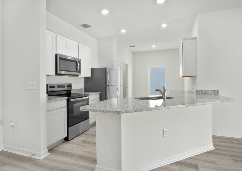 Kitchen with grey granite countertops, white cabinets, and stainless steel appliances