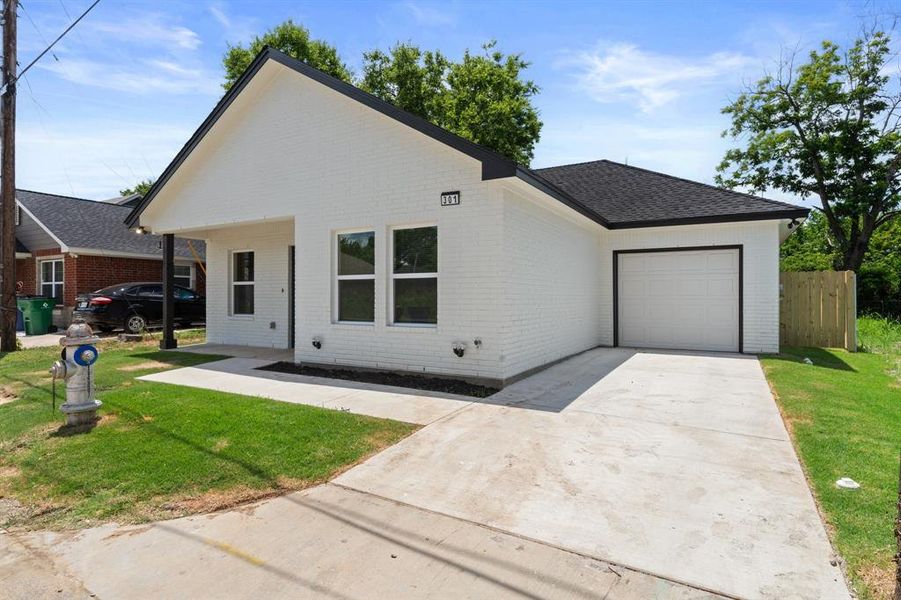 View of front facade featuring brick siding, an attached garage, driveway, and a shingled roof View of front facade featuring brick siding, an attached garage, driveway, and a shingled roof
