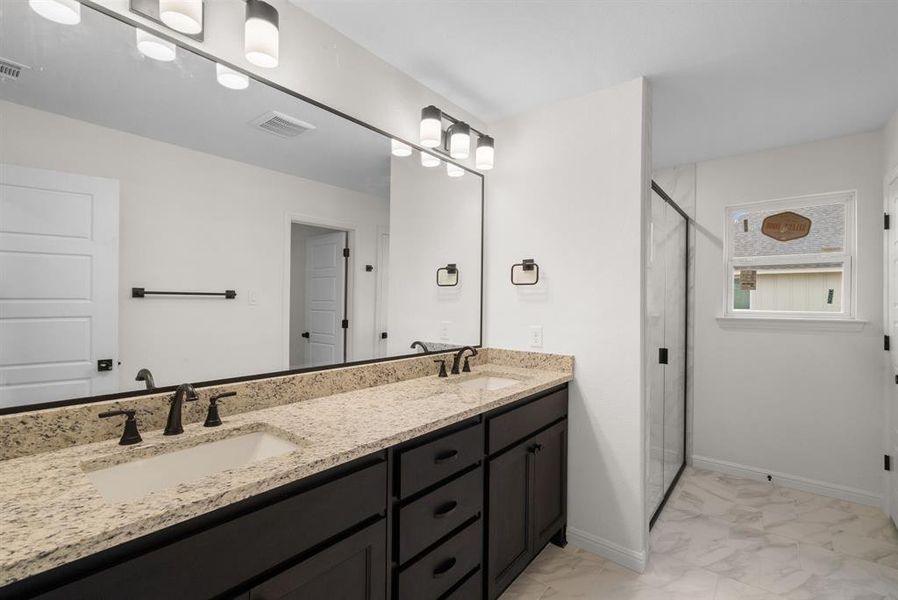 Bathroom featuring a shower with door and vanity Bathroom featuring a shower with door and vanity