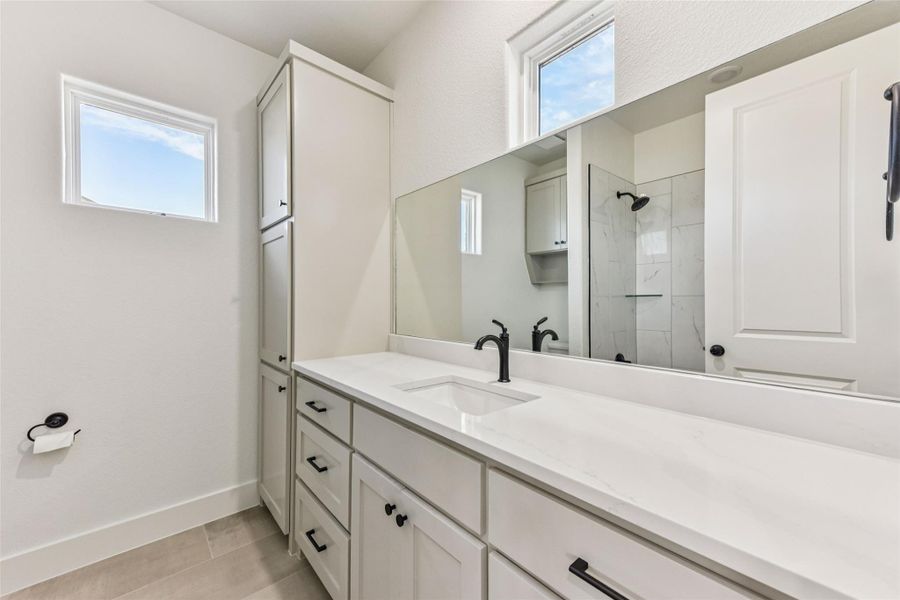 Full bath featuring vanity and tiled shower