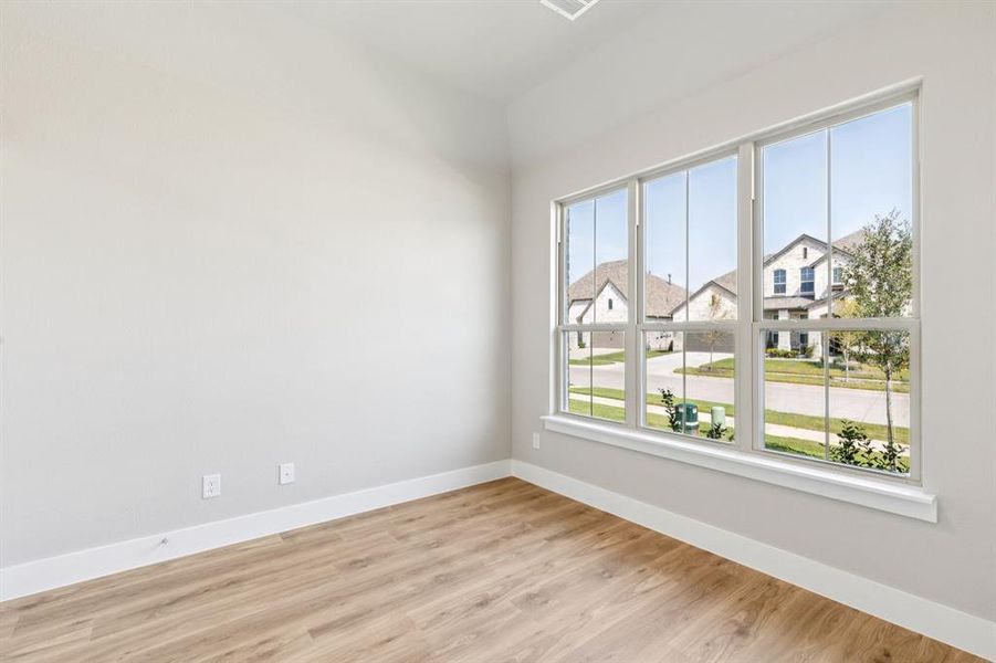 Empty room with light wood-style flooring and a residential view