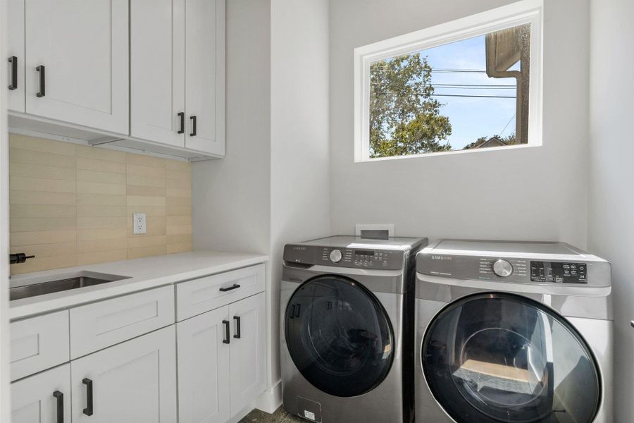 Washroom with cabinet space and washing machine and dryer