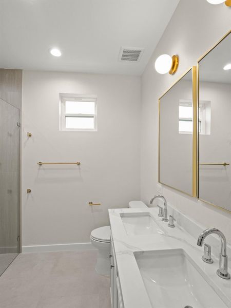 Bright bathroom featuring a dual vanity with white countertops, chrome fixtures, and individual rectangular sinks