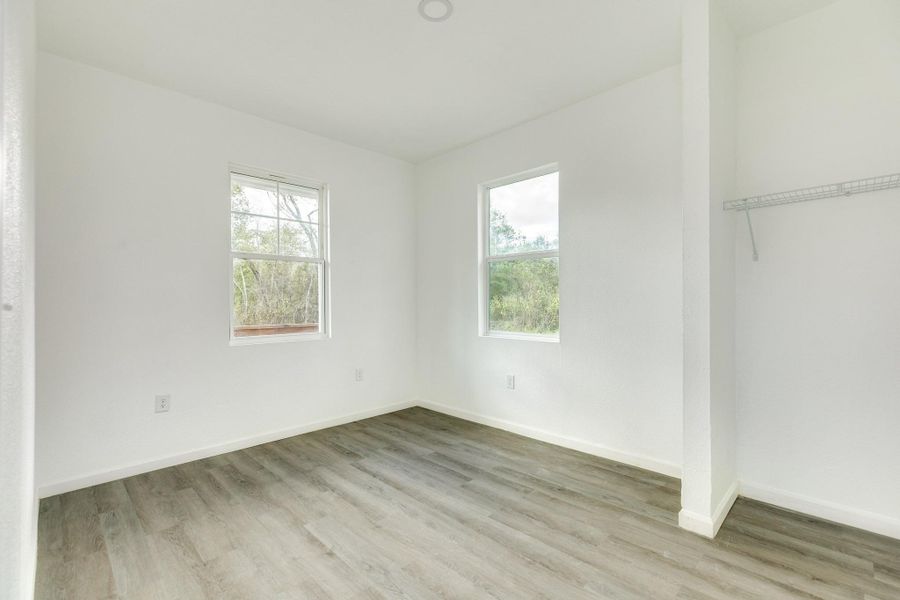 Bright primary bedroom filled with natural light and serene views of the large 11,000 lot