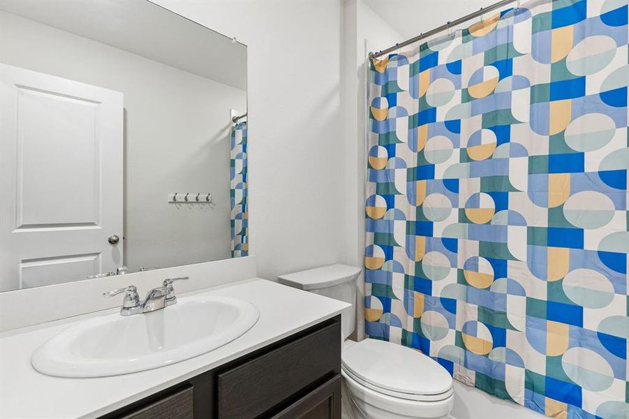 Bathroom with vanity and curtained shower Bathroom with vanity and curtained shower